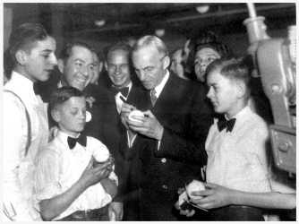Henry Ford signing baseballs at the Ford Trade School in New York